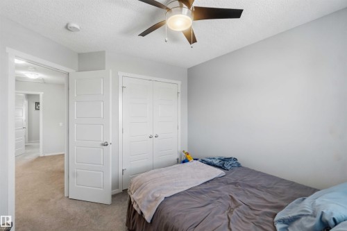 Bedroom featuring a ceiling fan with light, white paneled doors, and neutral carpeting - 940 East Gate, Edmonton, AB 