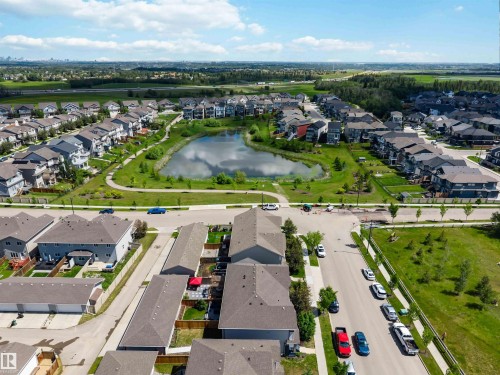 Aerial perspective showcasing a residential community with a central pond and green spaces - 940 East Gate, Edmonton, AB 