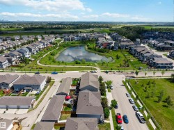 Aerial perspective showcasing a residential community with a central pond and green spaces - 