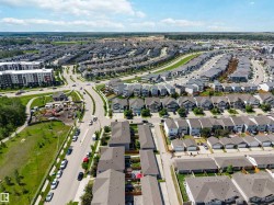 Aerial perspective of a developed residential area featuring a mix of detached homes and multi-story apartment buildings - 