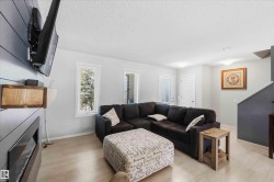 Living area featuring light wood-finish flooring, white walls, and a shiplap accent wall - 