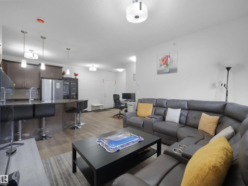 Open-concept living area featuring wood-finish flooring - 415 2203 44 Ave, Edmonton, AB 