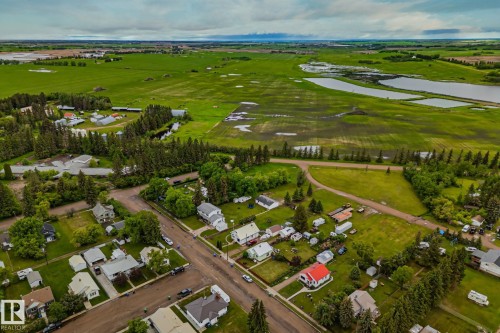 Aerial perspective showcasing a residential community surrounded by expansive green fields - 5305 51 Street, Willingdon, AB 