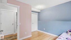 Bright room featuring wood-finish flooring, white baseboards, and a white ceiling with a flush-mount light fixture - 