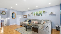 Expansive living area with wood-finish flooring and recessed lighting - 