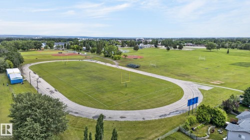 Recreational facility featuring a large grass field, an oval track, and multiple goalposts - 86 Heritage Crescent, Stony Plain, AB 