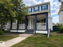 Two-story residence featuring a covered front porch with white railings, blue columns, and matching blue shutters - 12207 16 Avenue, Edmonton, AB 
