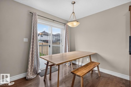 Dining area featuring a sliding glass door with exterior deck access, recessed lighting, wood-finish flooring, and a semi-flush mount fixture - 12032 167B Avenue, Edmonton, AB 
