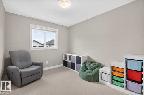 Spacious room featuring neutral-toned walls, a large window with white trim, and a textured ceiling - 12032 167B Avenue, Edmonton, AB 