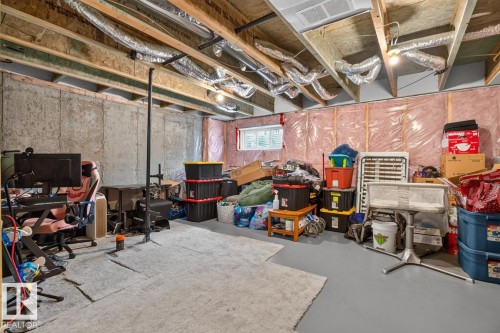 Unfinished basement space featuring exposed wood joists and ductwork, concrete walls, a small window, and a gray concrete floor - 12032 167B Avenue, Edmonton, AB 