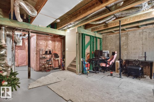 Unfinished basement space with exposed concrete walls, visible wood framing, and open ceiling joists - 12032 167B Avenue, Edmonton, AB 