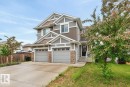 Two-story residential exterior featuring a two-car garage, stone accents, horizontal and shake siding, and a concrete driveway - 12032 167B Avenue, Edmonton, AB 