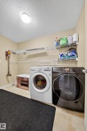 Laundry area featuring tile flooring, neutral wall tones, overhead lighting, and white wire shelving - 