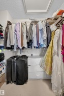 Walk-in closet featuring wire shelving, hanging rods, and an integrated three-drawer cabinet - 