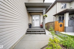 Neutral-toned siding exterior with a welcoming entryway featuring a covered porch and white front door with decorative glass - 