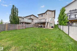 Expansive grassy yard with wood fencing and a chain-link fence - 