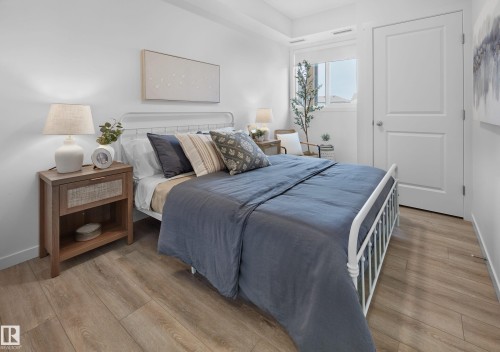 Bedroom featuring wood-finish flooring and a window with white blinds - 206 860 Secord Boulevard, Edmonton, AB 