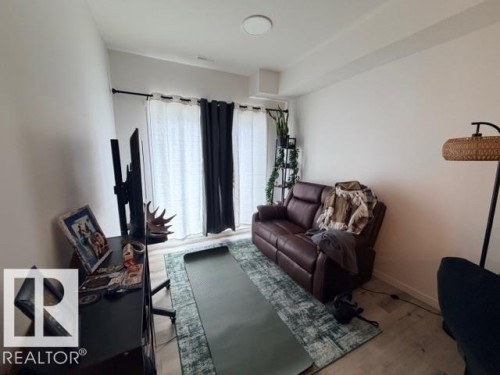 Bright room featuring wood-finish flooring, white walls, and a ceiling light fixture - 206 860 Secord Boulevard, Edmonton, AB 