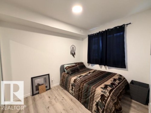 Room featuring light wood-finish flooring, white painted walls, and a recessed ceiling light fixture - 206 860 Secord Boulevard, Edmonton, AB 