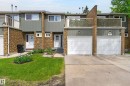 Townhouse exterior featuring brick and siding facade, private balconies, and concrete driveways with two garage doors - 13445 40 Street Nw, Edmonton, AB 