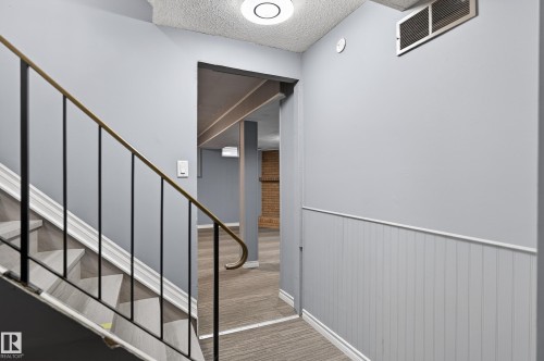 Staircase with wood-finish treads and a wrought iron handrail - 13445 40 Street Nw, Edmonton, AB 