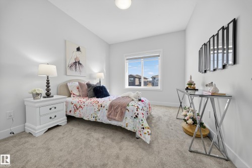 Carpeted bedroom featuring white walls and a large window - 372 Creekside Green, Leduc, AB 