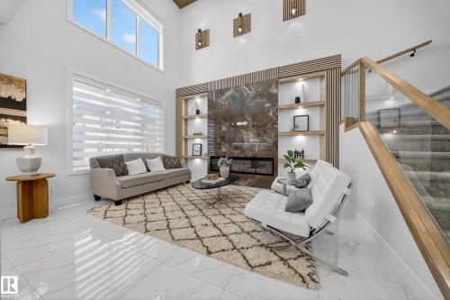 Two-story living area featuring a large window with privacy blinds, high ceilings, and light-toned tile flooring - 372 Creekside Green, Leduc, AB 