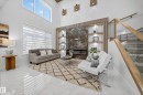 Two-story living area featuring a large window with privacy blinds, high ceilings, and light-toned tile flooring - 372 Creekside Green, Leduc, AB 