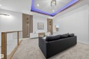 Recessed ceiling with blue accent lighting and a contemporary chandelier - 372 Creekside Green, Leduc, AB 