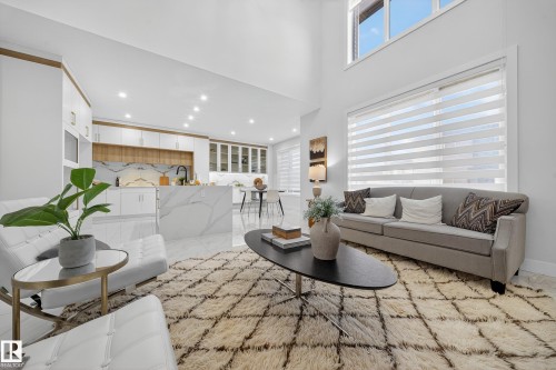 Open-concept living space with a two-story ceiling and large windows - 372 Creekside Green, Leduc, AB 