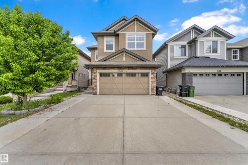 Two-story residence featuring a neutral-toned siding facade, stone accenting, and a gabled roofline - 5432 20 Avenue, Edmonton, AB 