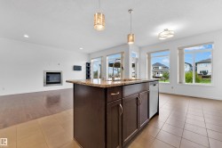 Central kitchen island with a stone countertop, integrated sink, and dishwasher - 