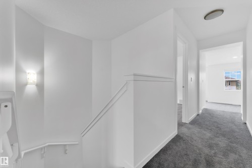 Upper-level hallway featuring plush gray carpeting and crisp white walls - 5432 20 Avenue, Edmonton, AB 