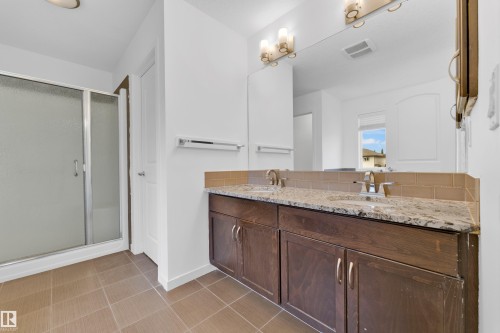 Double vanity with granite-style countertop, dual undermount sinks, and brushed nickel faucets - 5432 20 Avenue, Edmonton, AB 