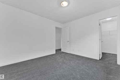 Interior room featuring neutral wall paint, gray carpeting, white baseboards, and a flush-mount ceiling light - 5432 20 Avenue, Edmonton, AB 