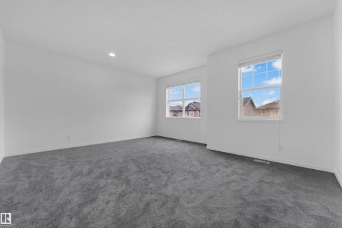 Spacious room featuring neutral carpeting and white walls - 5432 20 Avenue, Edmonton, AB 