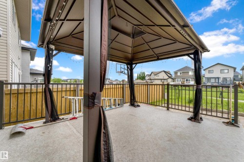 Expansive concrete patio featuring a gazebo with a fabric canopy and mesh side panels - 5432 20 Avenue, Edmonton, AB 