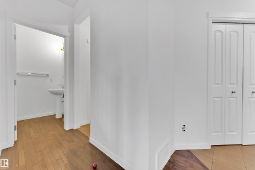 Interior hallway with wood-finish flooring transitioning to tile - 5432 20 Avenue, Edmonton, AB 