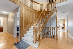 Curved staircase with wood balusters and carpeted treads - 