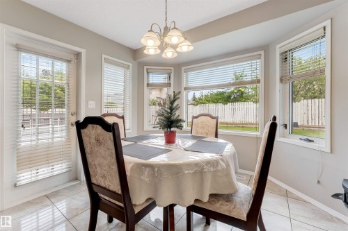 Bay window dining area with tile flooring and a multi-bulb chandelier - 4465 32A Street, Edmonton, AB 