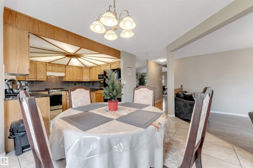 Dining area featuring a circular chandelier and ceramic tile flooring - 4465 32A Street, Edmonton, AB 