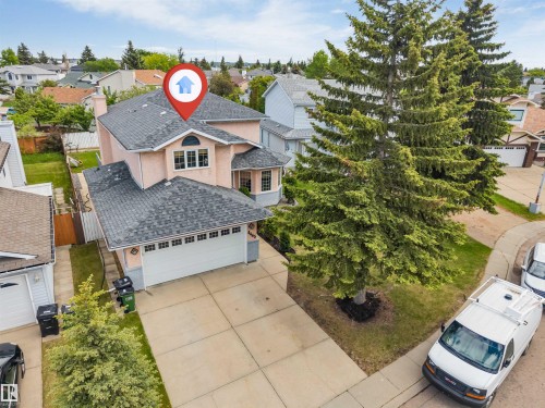 Two-story residence featuring a two-car garage, concrete driveway, and established front landscaping - 4465 32A Street, Edmonton, AB 