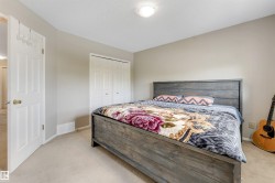 Interior room featuring neutral wall paint, light-colored carpeting, a ceiling-mounted light fixture, and white bi-fold closet doors - 