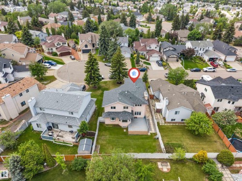 Aerial view showcasing a residential property with a multi-level deck overlooking a spacious lawn - 4465 32A Street, Edmonton, AB 
