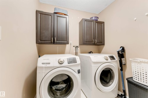 Dedicated laundry area featuring dark wood-finish cabinetry - 4465 32A Street, Edmonton, AB 
