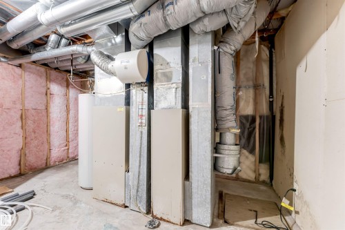 Basement utility area featuring exposed ductwork, insulation, hot water heater, and mechanical systems - 4465 32A Street, Edmonton, AB 