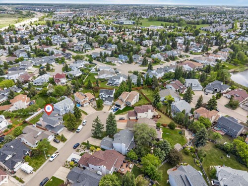 Residential property featuring a light grey exterior with dark grey roofing, situated within a tree-lined neighborhood - 4465 32A Street, Edmonton, AB 