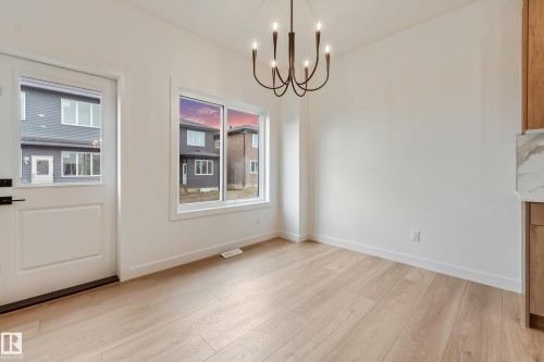 Well-lit interior featuring light wood-finish flooring and bright white walls - 4636 18 Avenue, Edmonton, AB 