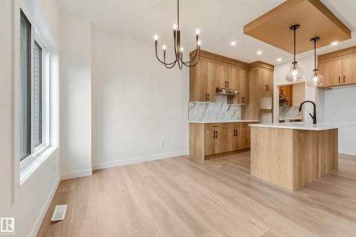Modern kitchen and dining area featuring light wood-finish flooring - 4636 18 Avenue, Edmonton, AB 