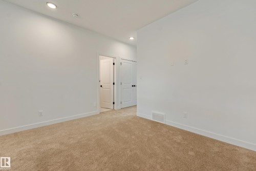 Neutral tone carpeting complements crisp white walls with recessed lighting - 4636 18 Avenue, Edmonton, AB 